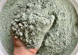 Hand holding gray-green micronized greensand